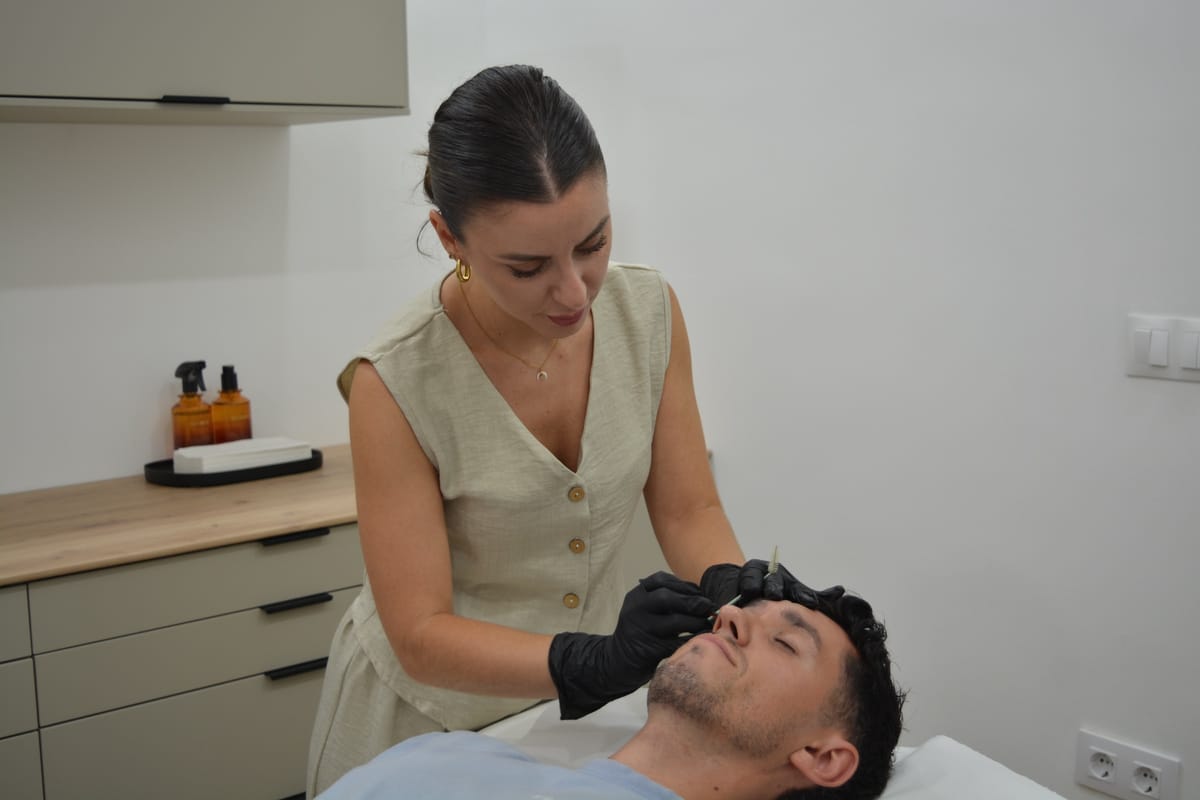Marta trabajando sobre las cejas de un cliente en el atelier
